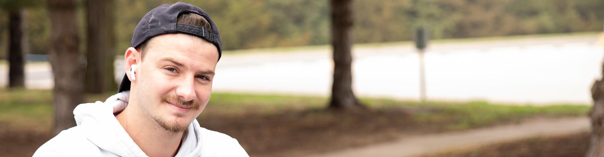 Student in white hoodie with phone