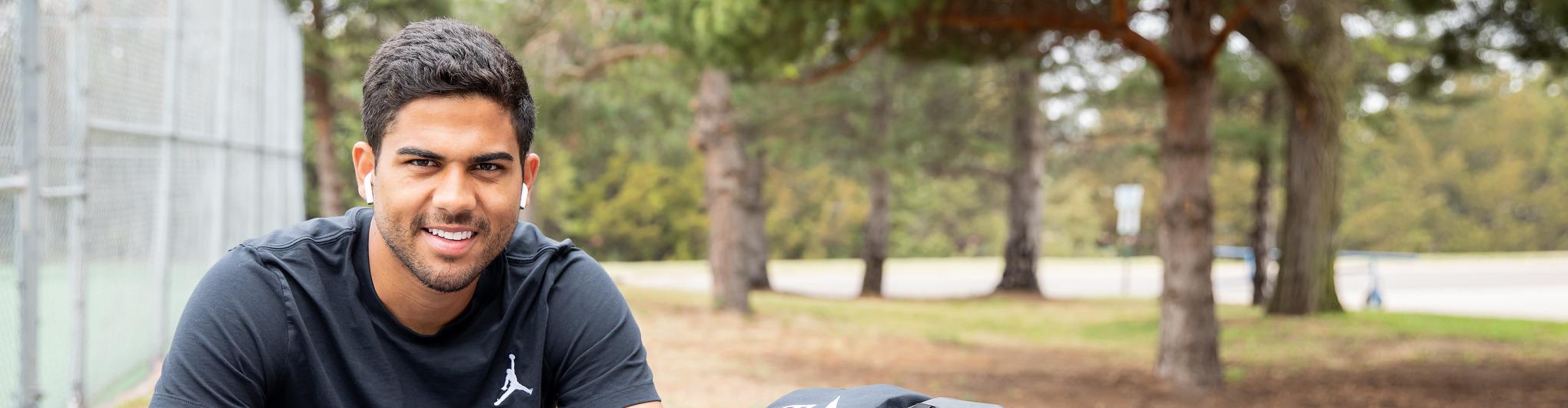 Student sitting at picnic table with laptop