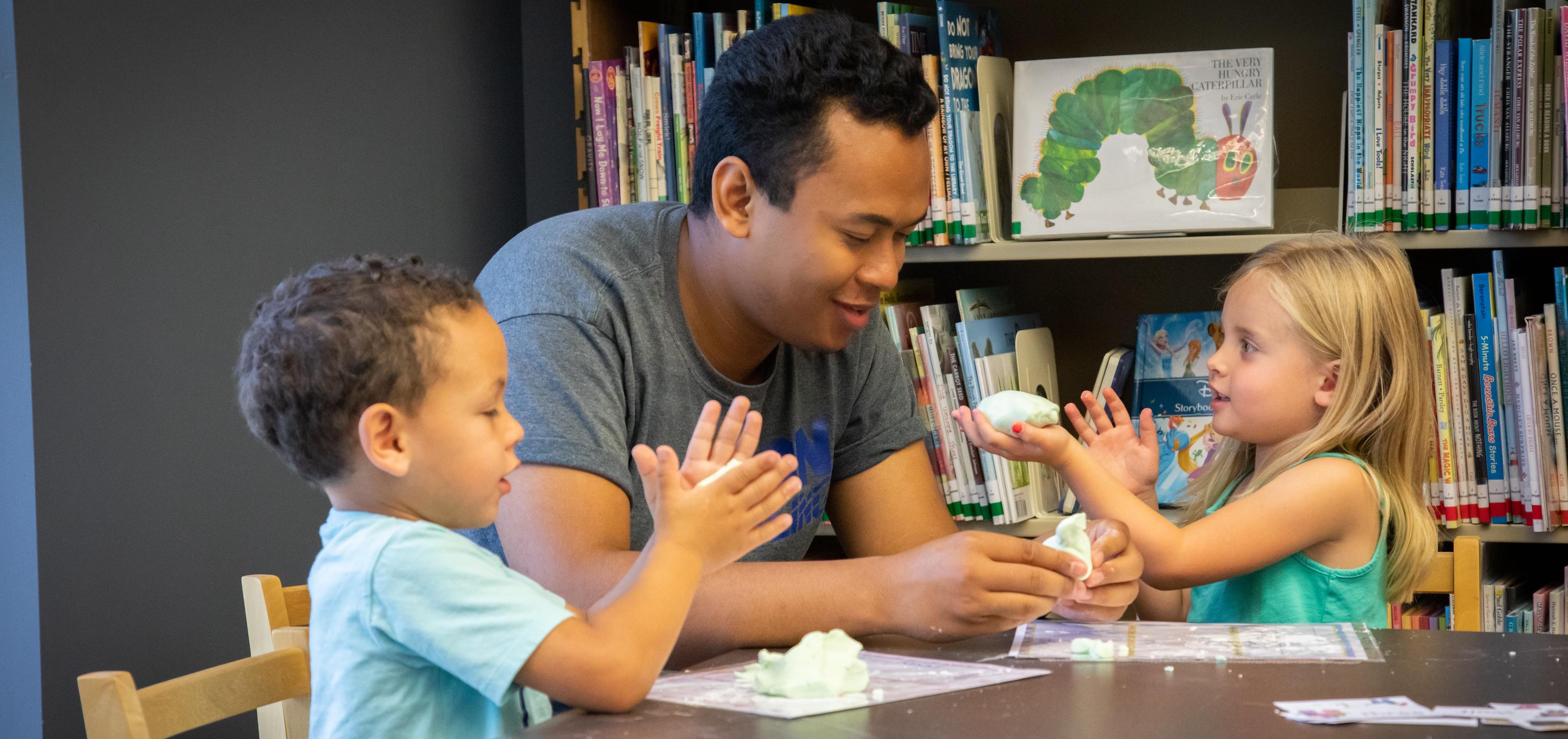 Early Childhood student helping children with craft